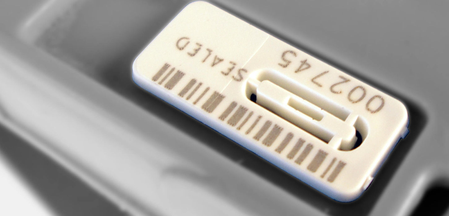 Unisto Syntra snap-on security seal applied to a box, close-up
